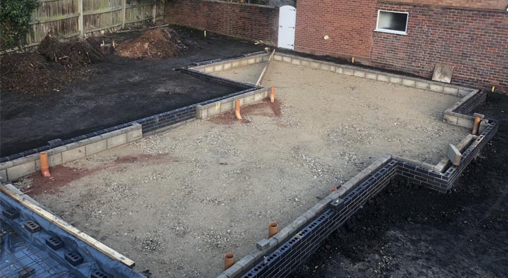Brickwork up to DPC with MOT sub base and drainage in place ready for concrete pad.