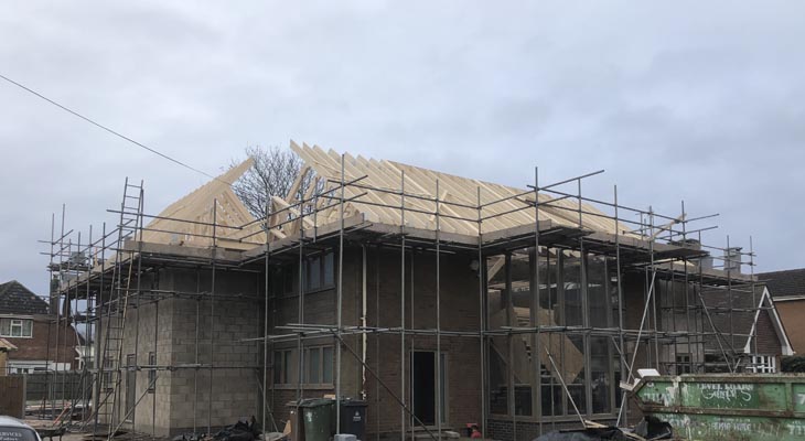 Wraparound extension blockwork up to wall height, roof being installed.
